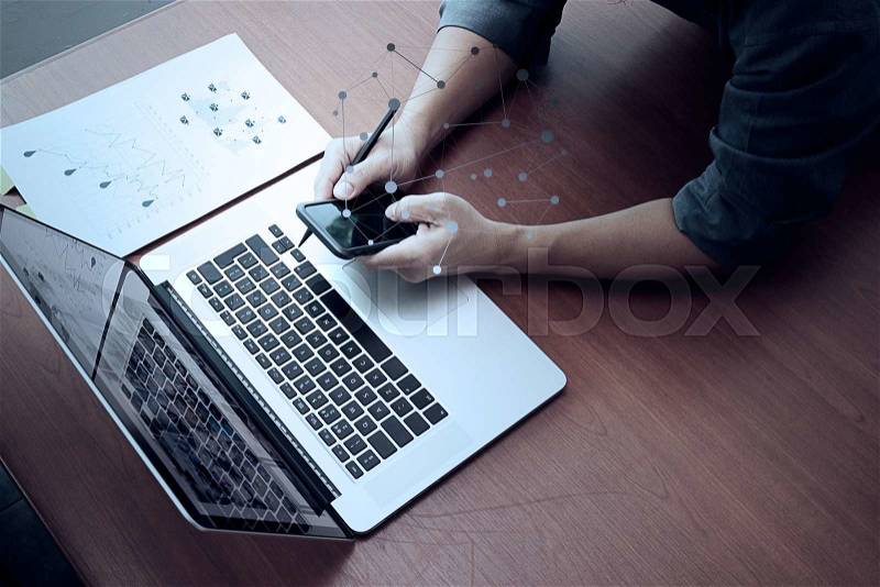 Top view of businessman hand working with new modern computer and smart phone and business strategy on wooden desk as concept , stock photo