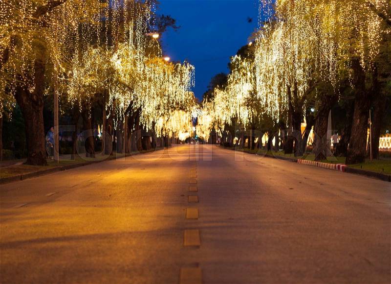 Street with lights on the side. The fire was decorated a tree along the road, stock photo