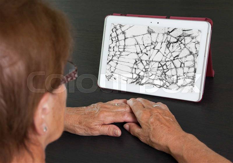 Senior lady with tablet, cracked screen, concept of insurance, stock photo