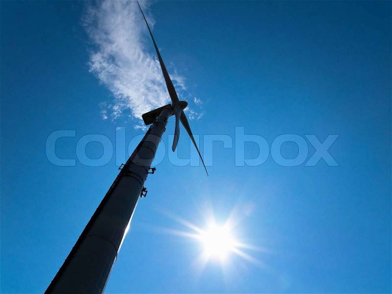 Moving wind turbine with bright blue sky, stock photo