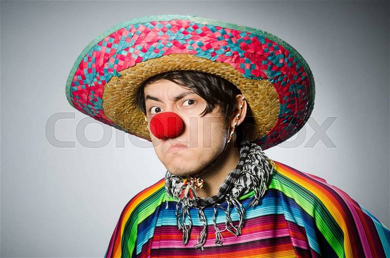 Man in vivid mexican poncho against gray, stock photo