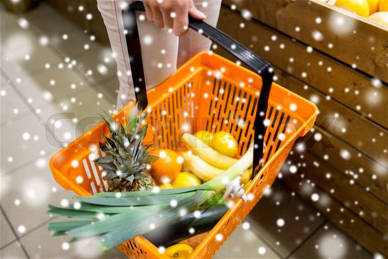 Sale, shopping, consumerism and people concept - close up of young woman with food basket in market over snow effect, stock photo