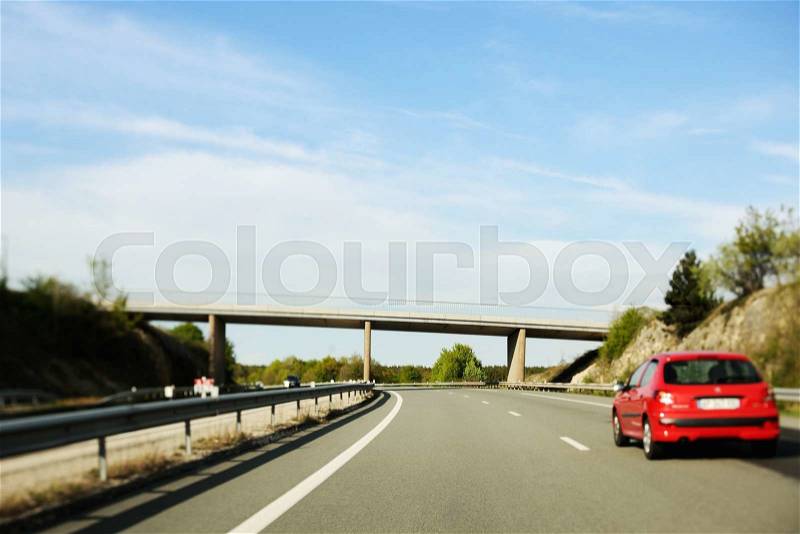 Red french car on typical French highway - tilt-shift lens used, stock photo