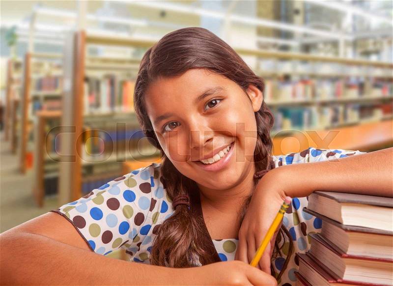Happy Hispanic Girl Student with Pencil and Books Studying in Library, stock photo