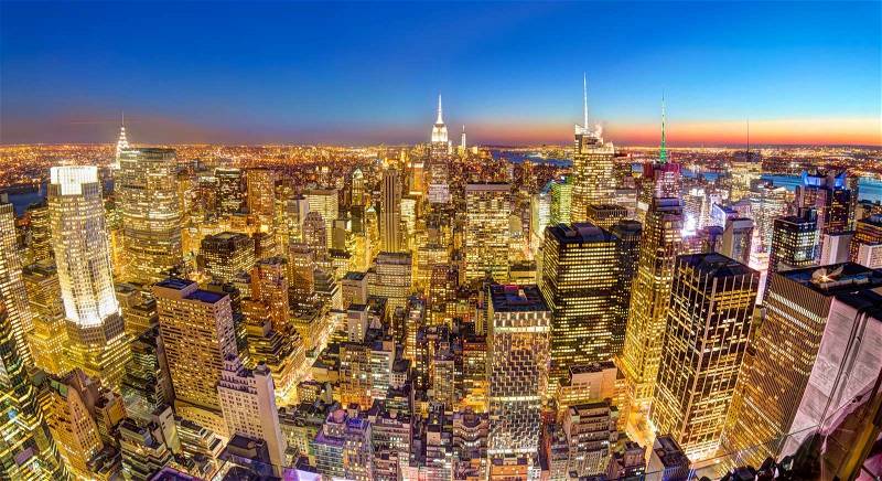 New York City. Manhattan downtown skyline with illuminated Empire State Building and skyscrapers at dusk. Panoramic composition, stock photo