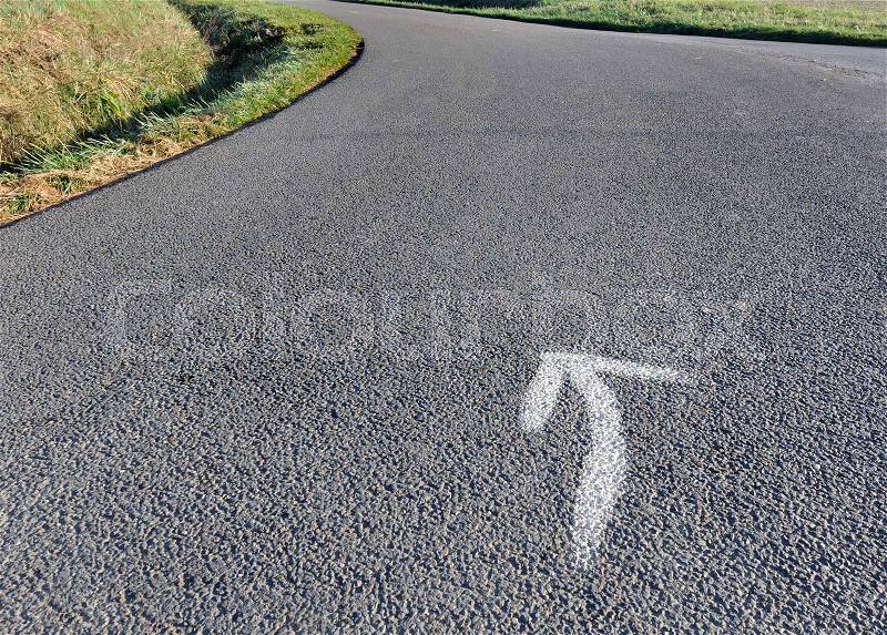 Close on a arrow on asphalt country road in a curve , stock photo
