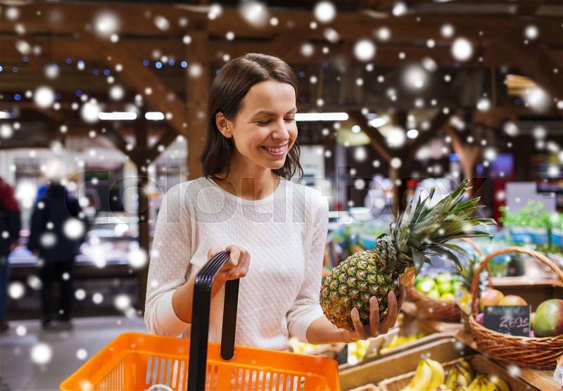 Sale, shopping, consumerism and people concept - happy young woman with food basket in market or grocery store over snow effect, stock photo