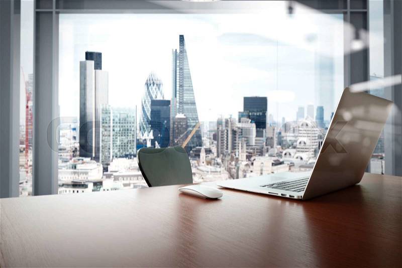 Office workplace with laptop and smart phone on wood table with london city background , stock photo