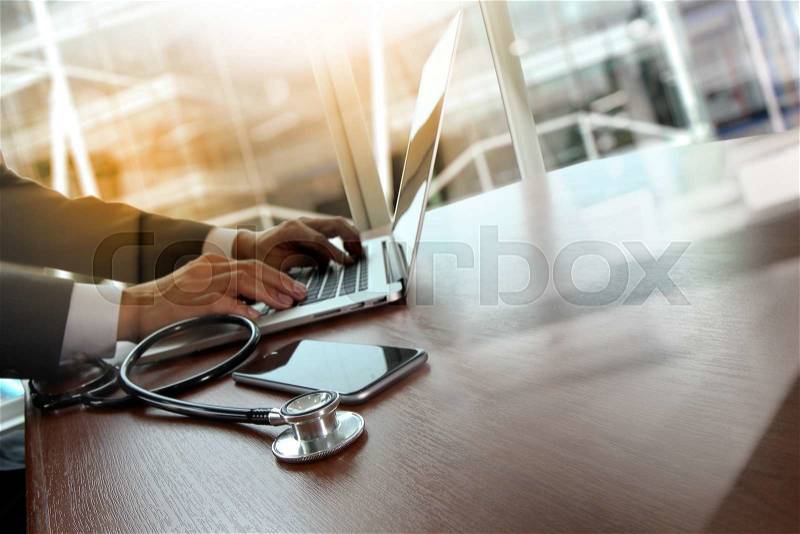 Doctor working at workspace with laptop computer in medical workspace office and medical network media diagram as concept, stock photo