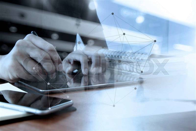Double exposure of designer hand working with digital tablet and laptop and notebook stack and eye glass on wooden desk in office with network diagram, stock photo