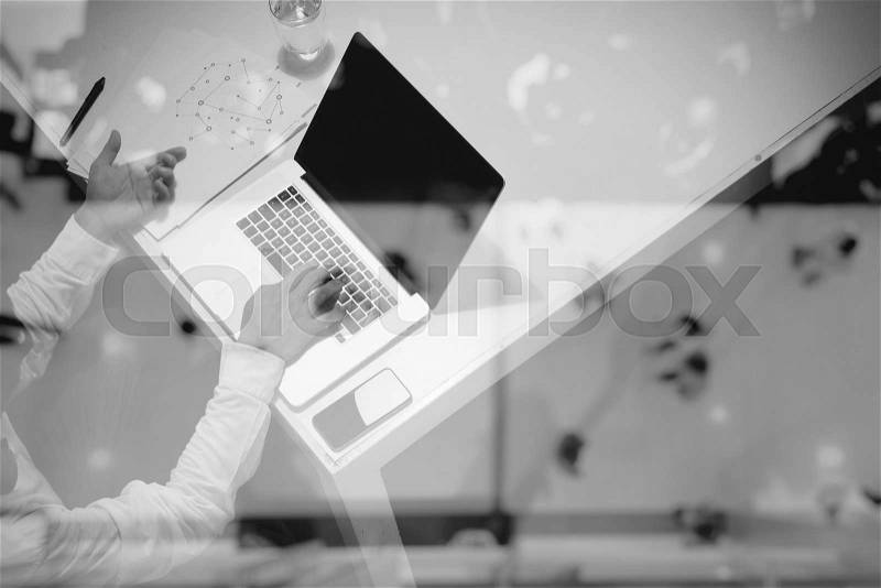 Top view of business documents on office table with digital tablet and man working with smart laptop computer, stock photo