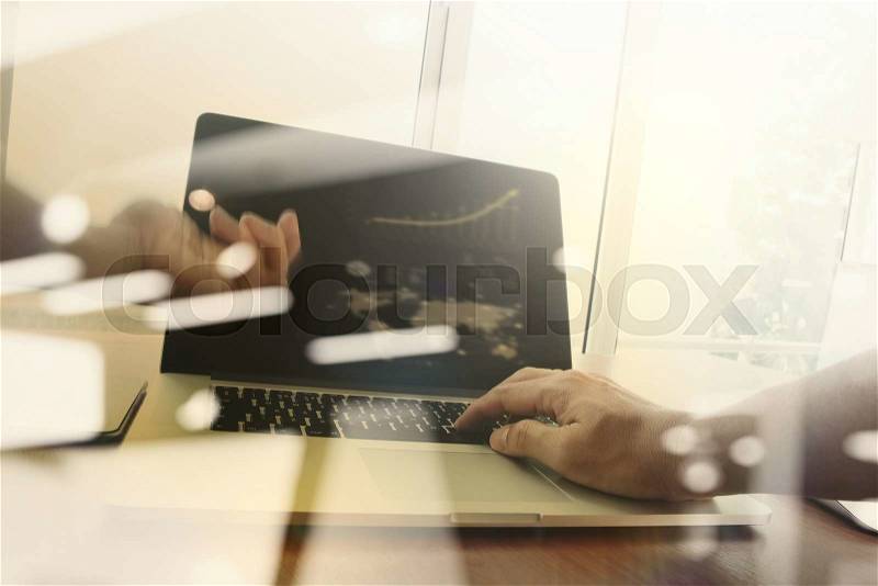 Close up of business man hand working on laptop computer with business strategy diagram on wooden desk as concept, stock photo