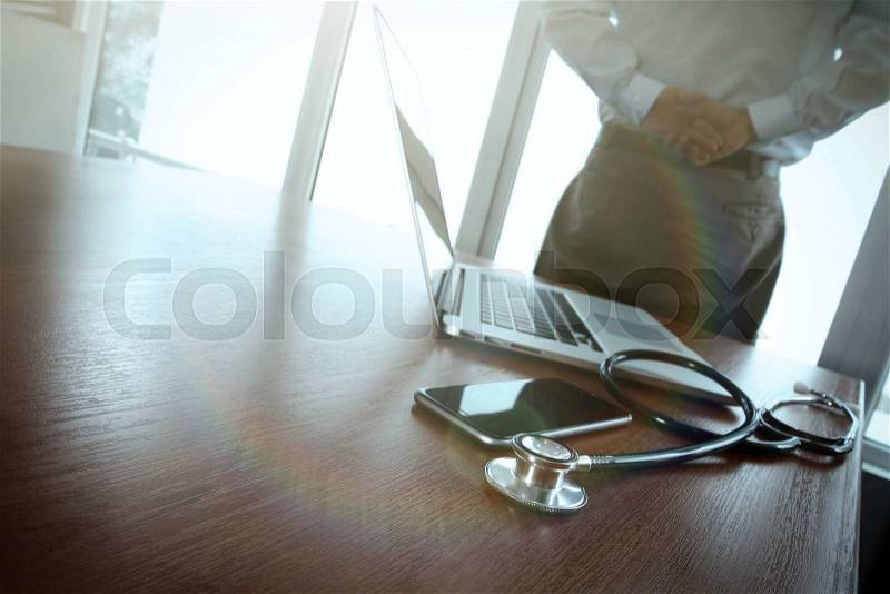 Doctor working at workspace with laptop computer in medical workspace office and medical network media diagram as concept, stock photo