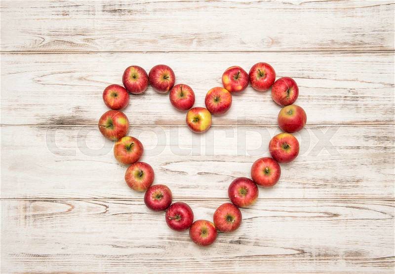 Red apples heart over rustic wooden background. Love concept, stock photo
