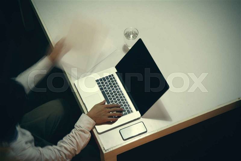 Top view of man working with business documents on office table with digital tablet and man working with smart laptop computer, stock photo