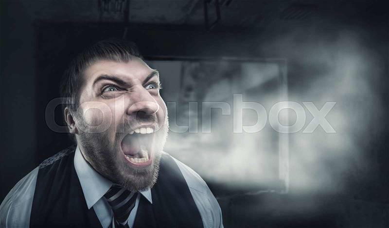Angry businessman screaming over gray background, stock photo