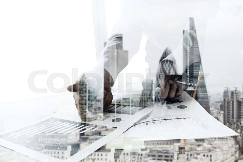 Double exposure of businessman working with new modern computer and london city blurred background, stock photo