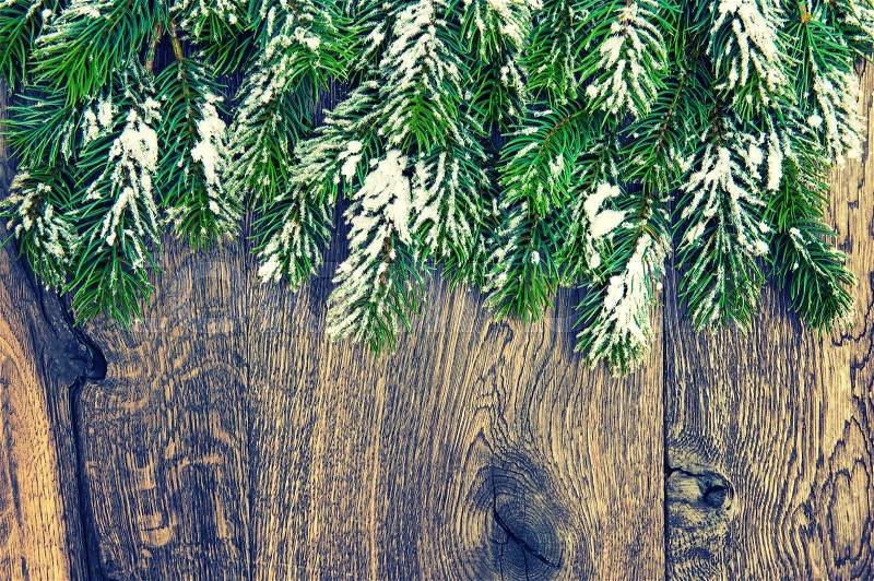 Christmas tree branches on rustic wooden background. Vintage style toned picture, stock photo