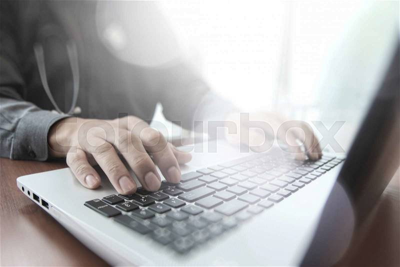 Doctor working with digital tablet and laptop computer in medical workspace office and overcast exposure effect, stock photo