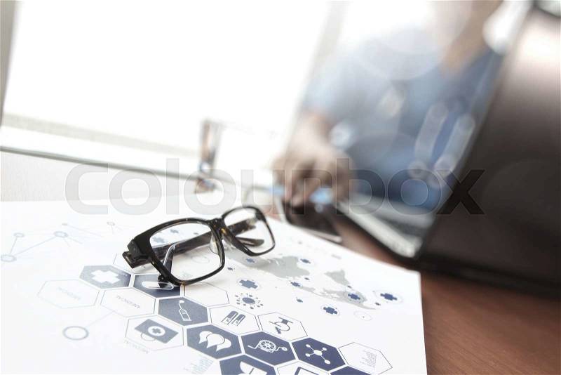 Doctor working with laptop computer and eye glass in medical workspace office and medical network media diagram as concept, stock photo