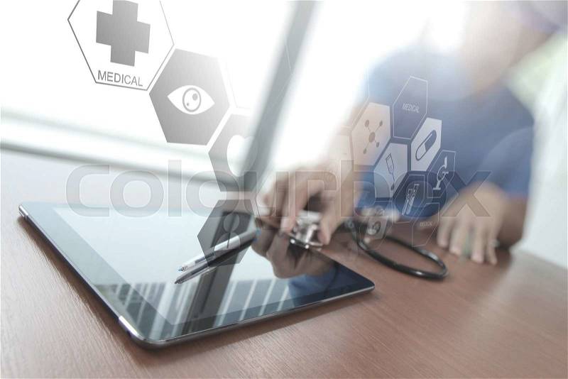 Doctor working with digital tablet in medical workspace office as concept with overcast exposure, stock photo