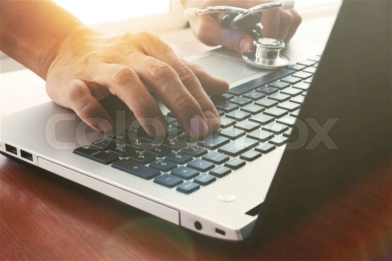 Doctor working with digital tablet and laptop computer in medical workspace office and overcast exposure effect, stock photo