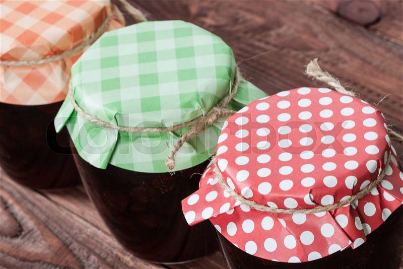 Jar with a strawberry jam on a wooden background, stock photo