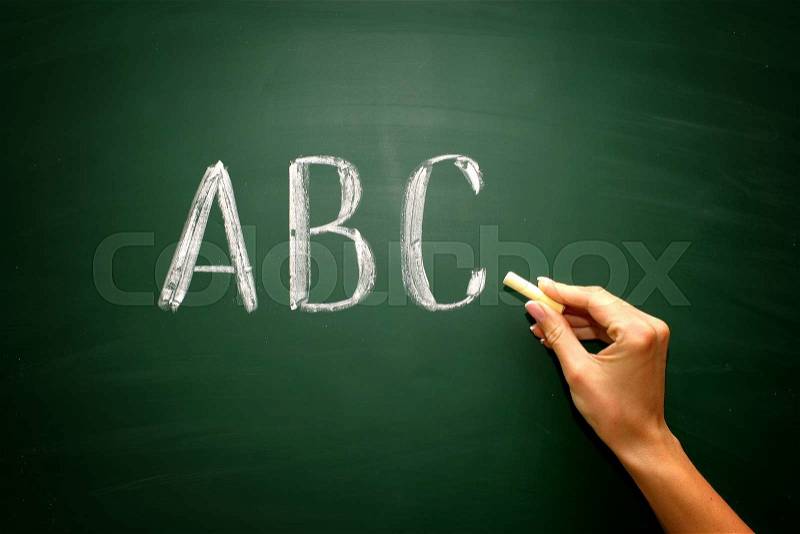 Abc letters with hand and chalk on blackboard , stock photo