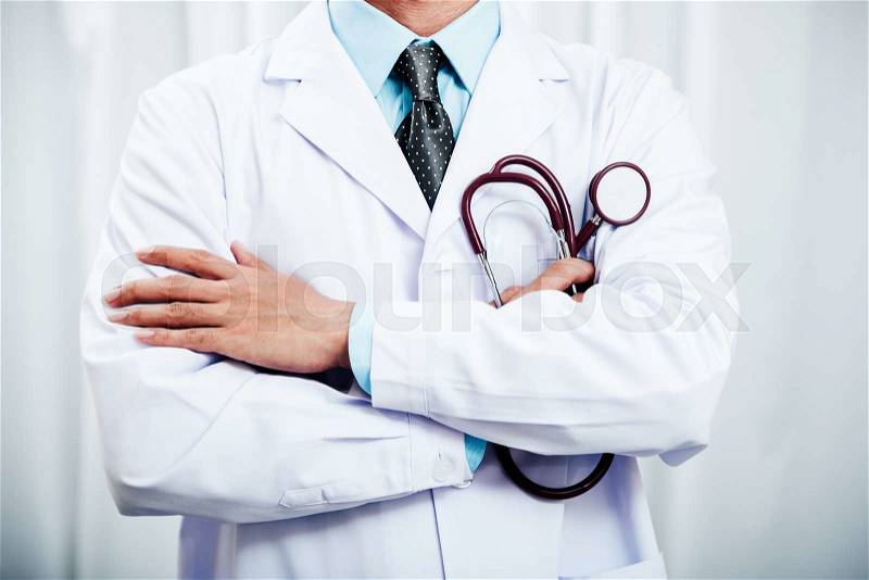 Close up of a doctor folding arms and holding a stethoscope, stock photo