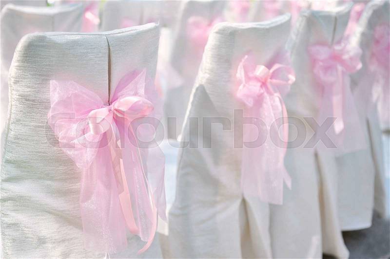 Decoration on wedding chairs pink bow, stock photo
