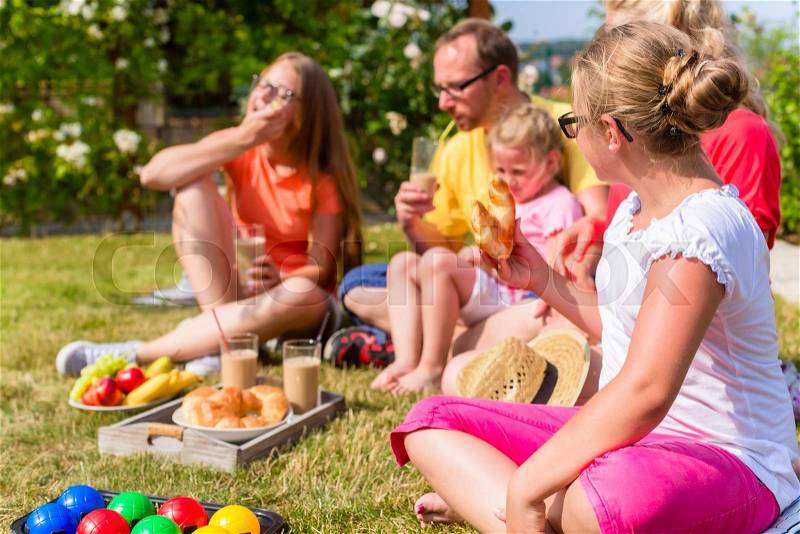Family having picnic in garden front of their home, stock photo