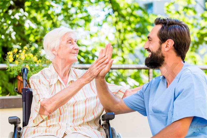 Senior woman and nurse giving High five in nursery home, stock photo