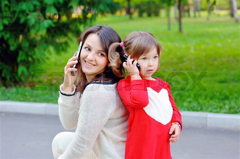 Mom with baby talking on phone, stock photo