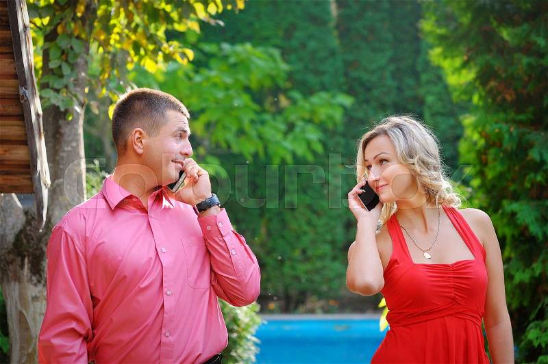 Young couple successful businessmen agree on the best deal. He was talking on the phone, it searches the internet for new business partners. , stock photo