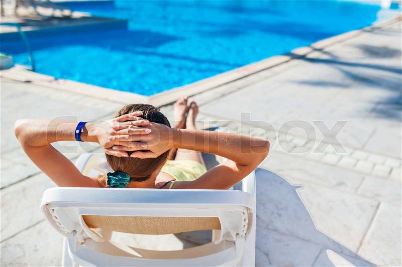 Woman chaise longue on the background of the pool at the hotel, stock photo