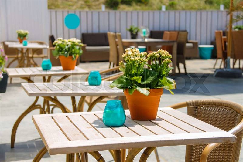 Flowers in pot and candles on the tables of beach cafe. Zandvoort, the Netherlands, stock photo