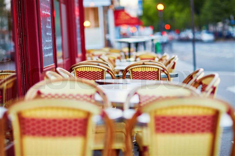 Tables of traditional outdoor French cafe in Paris, stock photo