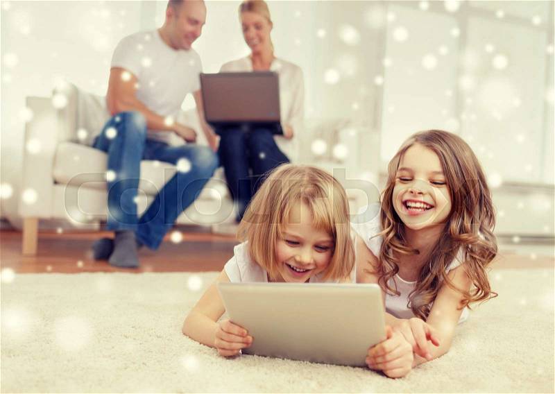 Family, home, technology and people - smiling mother, father and little girls with tablet pc computer over snowflakes background, stock photo