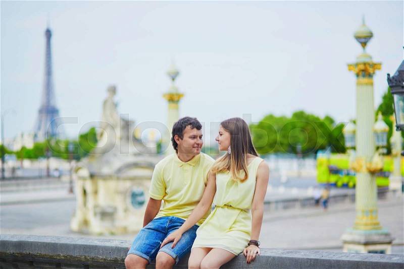 Romantic dating couple of tourist in Paris in the Tuileries garden, Eiffel tower is in the background, stock photo