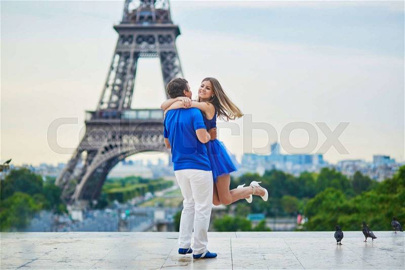 Beautiful young dating couple in Paris near the Eiffel tower, stock photo