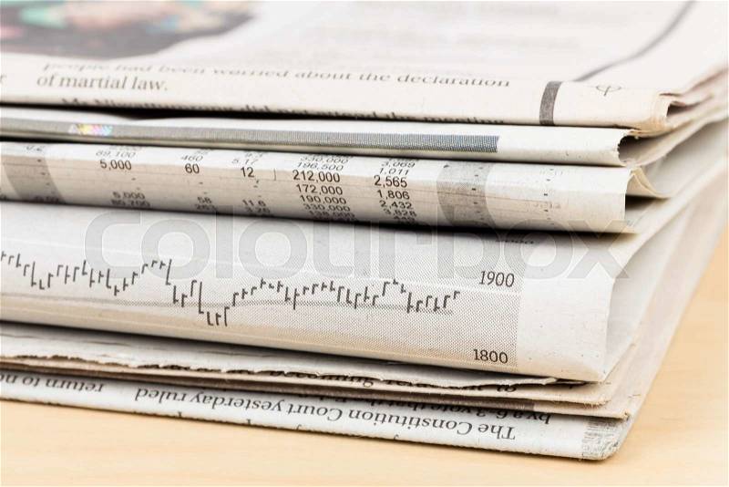 Stack of business newspapers on table, stock photo