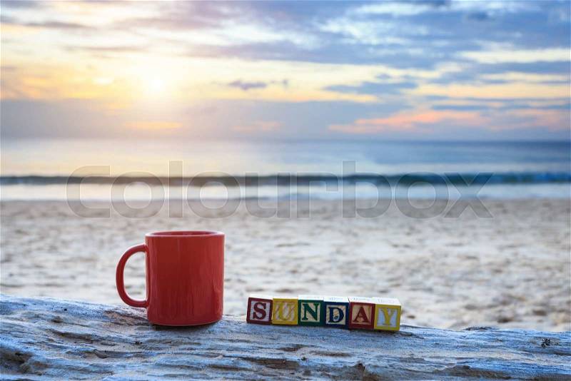 Close up coffee cup on wood log at sunset or sunrise beach, stock photo