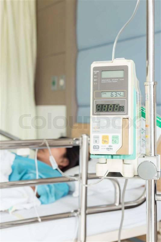 Female patient with IV drip needle piercing in hospital room, Focus on Infusion Pump Intravenous IV Drip, stock photo