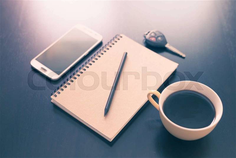 Book and coffee cup on black wooden table background, stock photo