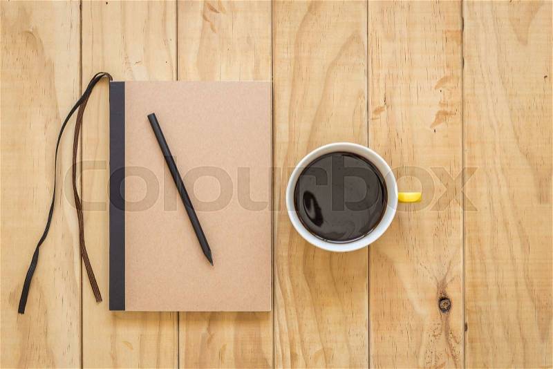 Top view of brown book and coffee cup on wooden table background, stock photo