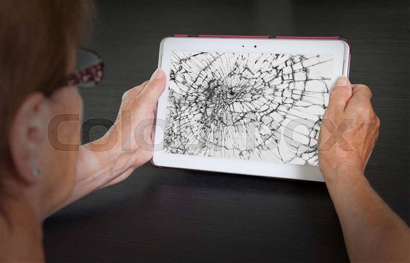 Senior lady with tablet, cracked screen, concept of insurance, stock photo