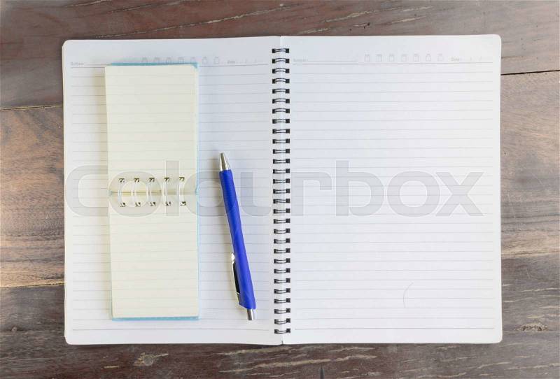 Blank notebook and pen on old wooden office desk, stock photo