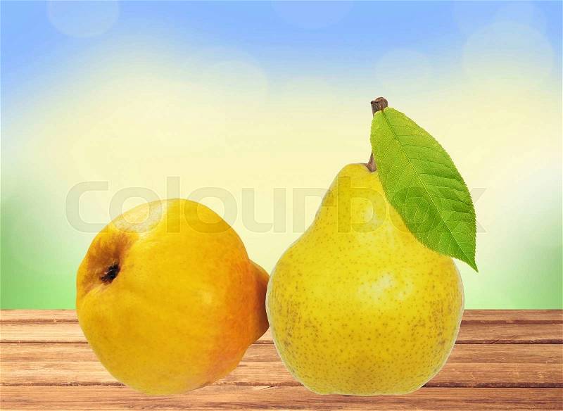 Two sweet pears on wooden table over bright nature background, stock photo