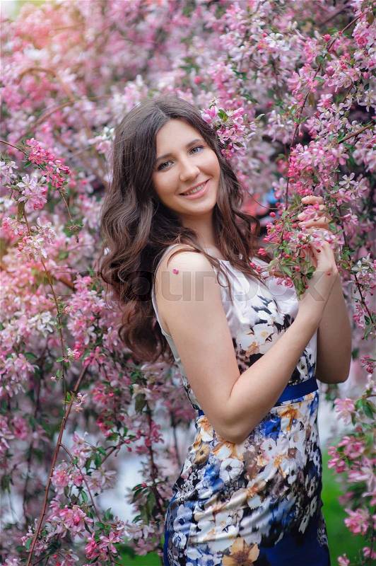 Happy woman in pink flowers in spring wild apple.\, stock photo