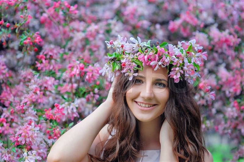 Young woman in a park with a spring wreath, stock photo